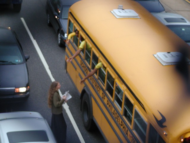 Lauren Murch passes out literature to students on bus.