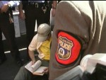 Michael Marcavage flips through a hymnal before being taken to an awaiting patty wagon.