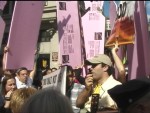 The Pink "Angels" blow whistles and block Scripture banners with large pink styrofoam, surrounding Michael Marcavage as he preaches.