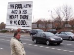 Kevin Keener hold banner: "THE FOOL HATH SAID IN HIS HEART, THERE IS NO GOD." (Psalm 14:1)
