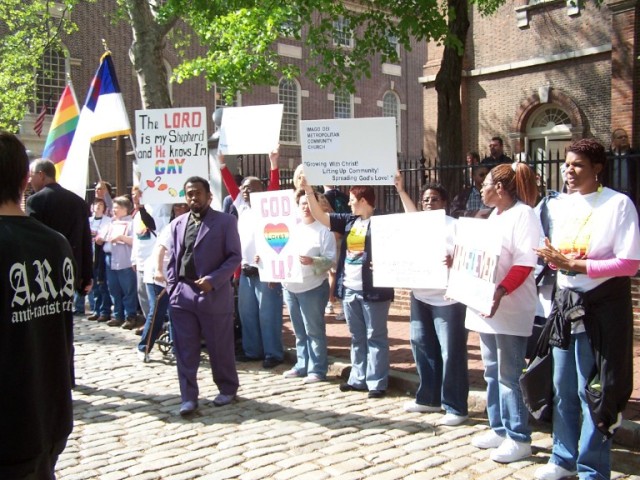 A false teacher wears a purple suit outside of the histroic Christ Church while those who turn their ears away from the truth (2 Tim. 4:3-4) gather behind him.