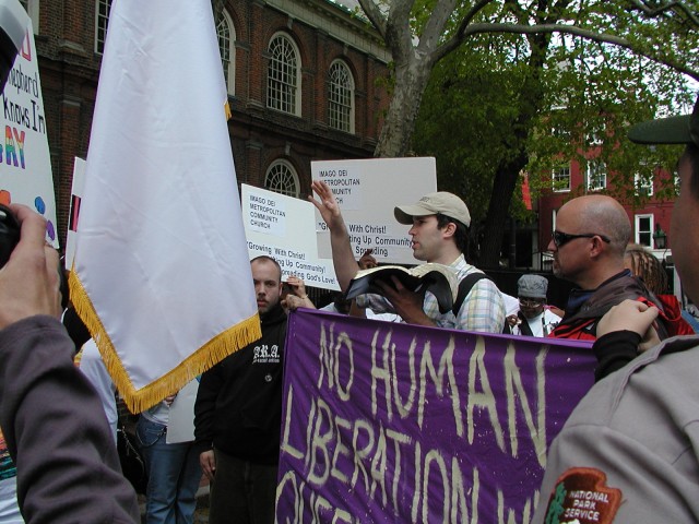 Michael preaching outside of the historic Christ Church as homosexuals attempt to block him.  Inside, false teachers assert that all faiths lead to heaven and that homosexual acts are not sinful.  Michael preaches (left) with attorney Scott Shields (right).