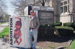 Michael stands outside of Pastor Wolfe's church with truth